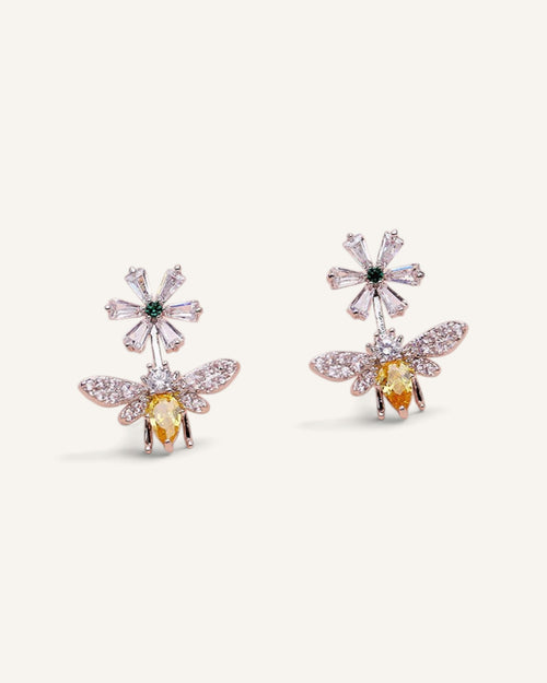 Lunéra de Paris silver tone stud earrings featuring a bee and daisy motif with clear and yellow zircon accents.