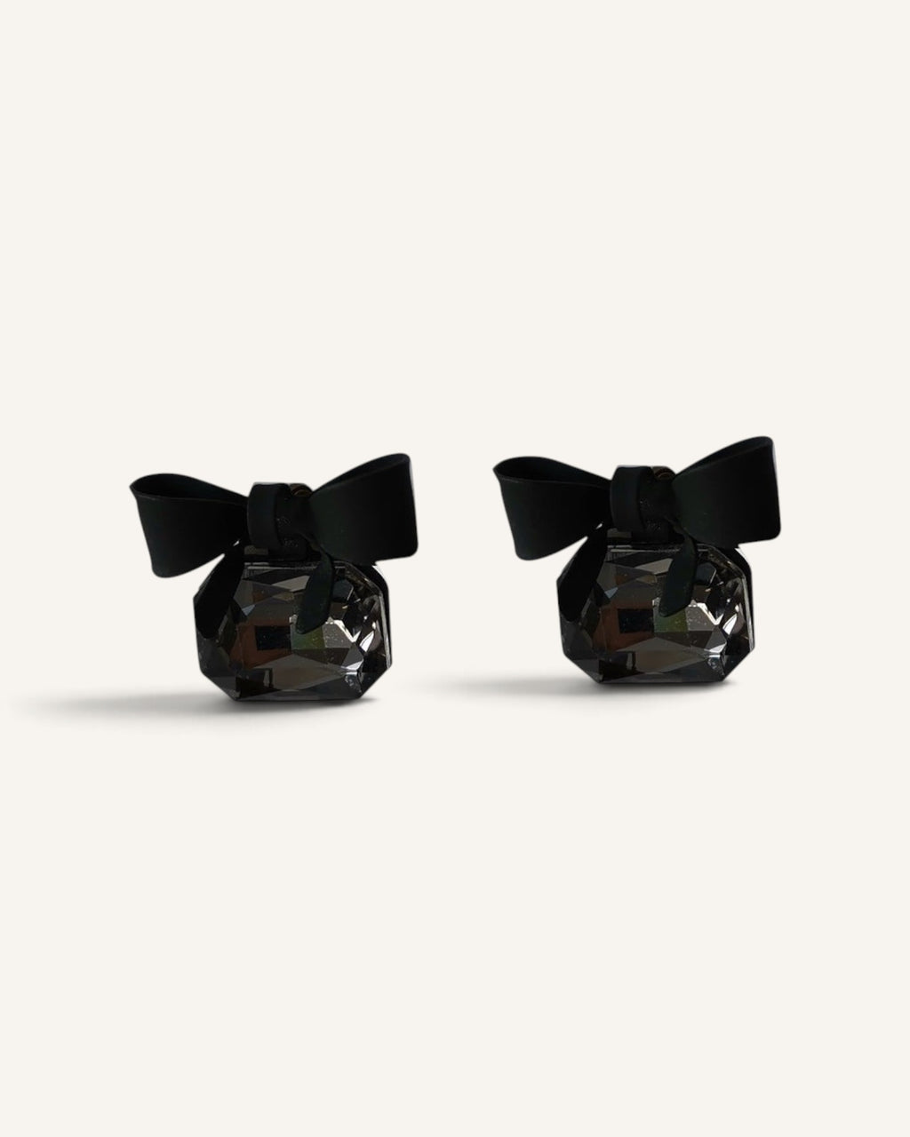 Lunéra de Paris stud earrings featuring matte black bows and faceted smoky grey rectangular crystals on silver posts.