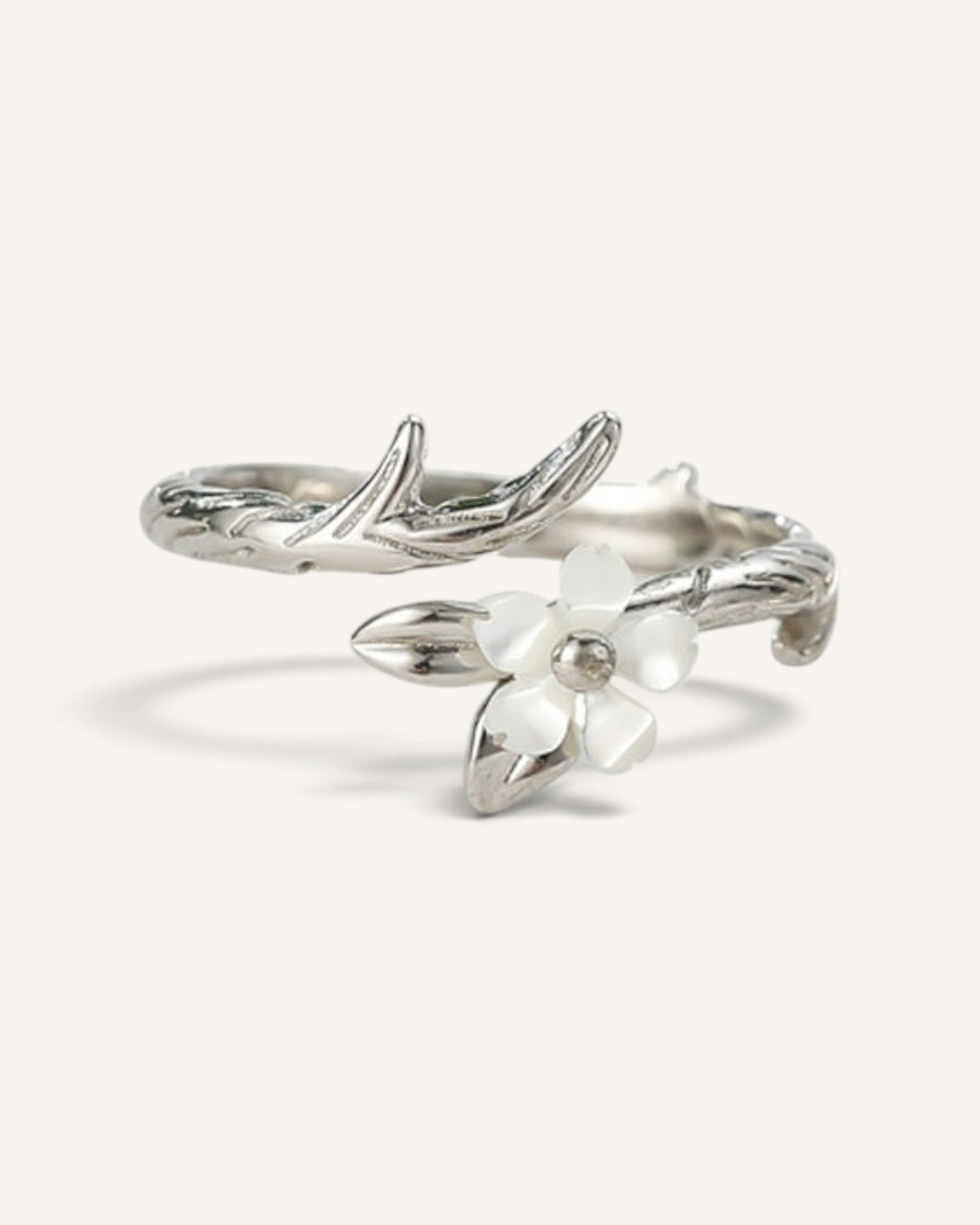 Lunéra de Paris silver-tone adjustable ring featuring a textured branch design with a delicate white blossom accent.