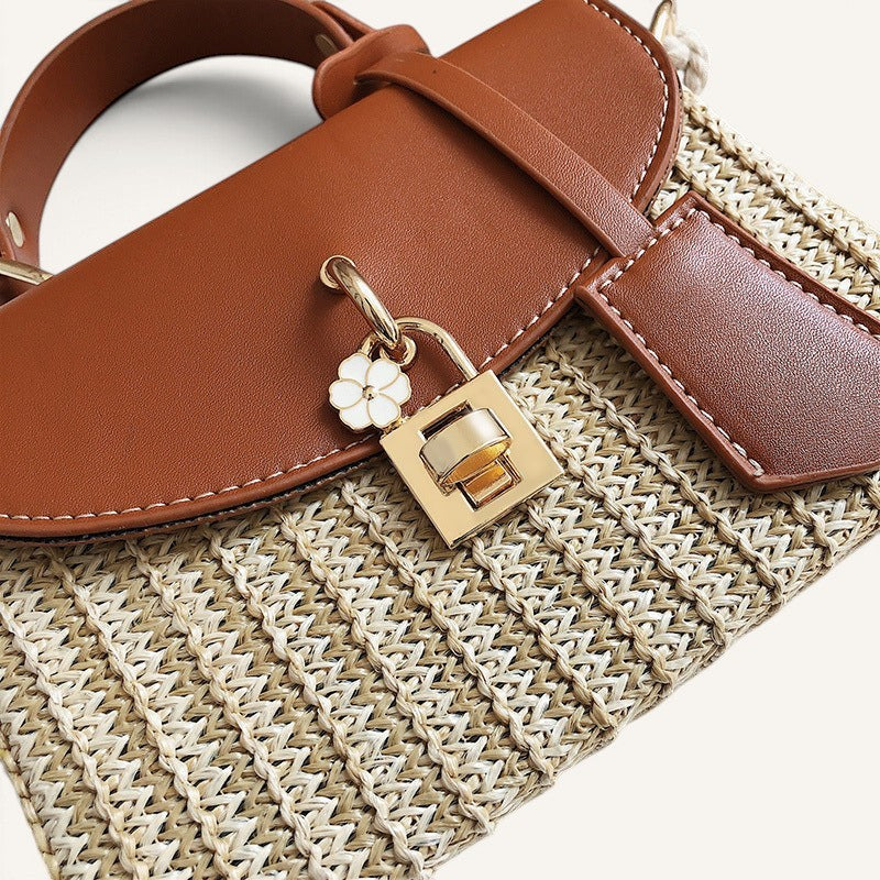 Lunéra de Paris cognac brown and woven straw crossbody bag with a floral charm turn-lock closure and top handle