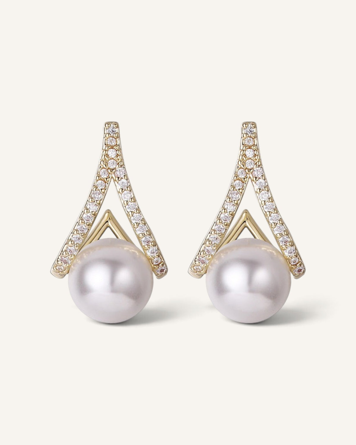Lunéra de Paris geometric V-shaped gold stud earrings featuring a central pearl and stone-encrusted detailing.