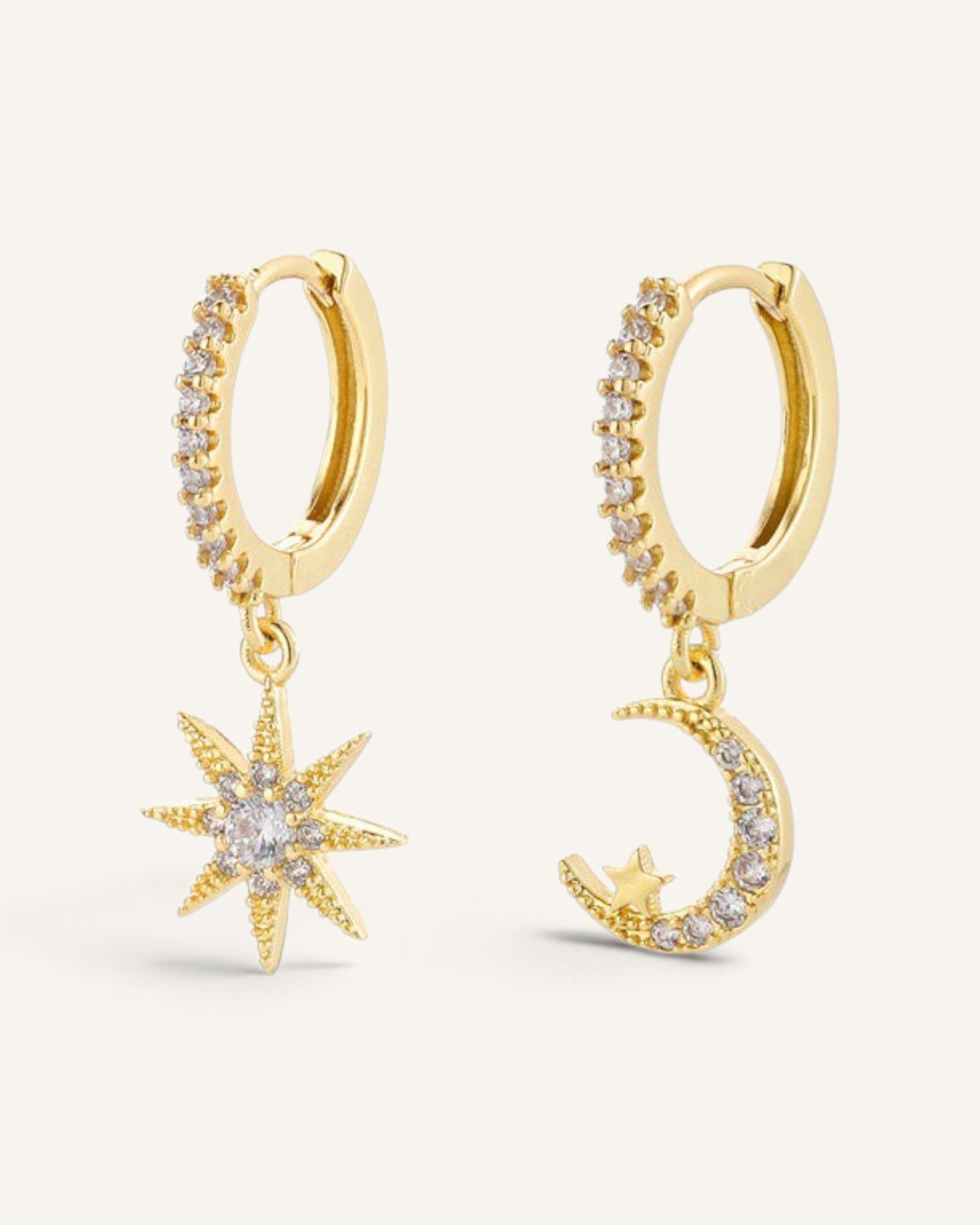 Lunéra de Paris gold asymmetric hoop earrings featuring a sparkling star charm and a crescent moon with crystal accents.