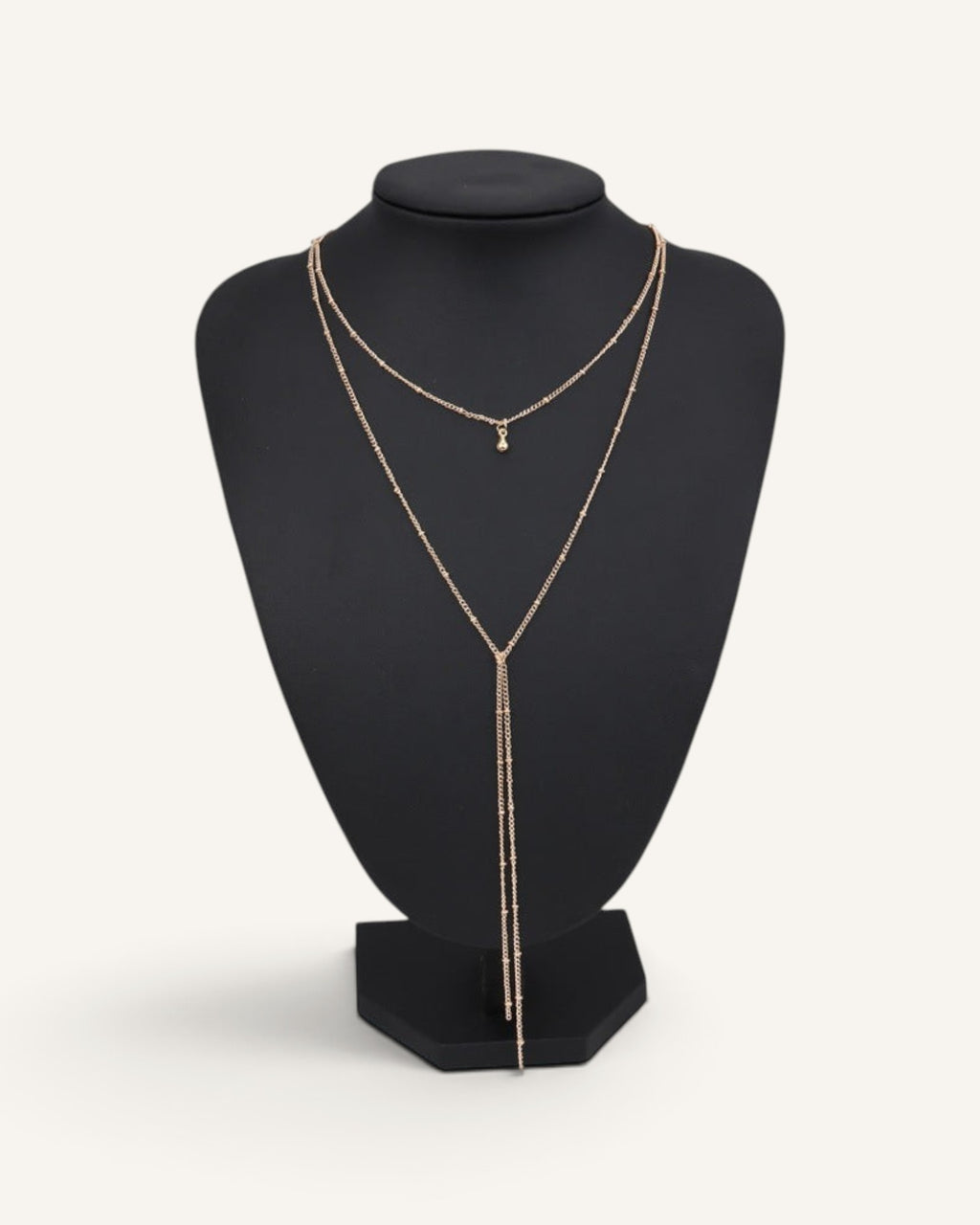 Lunéra de Paris double-layer gold lariat necklace with satellite chain and droplet pendant on a black display bust