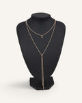Lunéra de Paris double-layer gold lariat necklace with satellite chain and droplet pendant on a black display bust