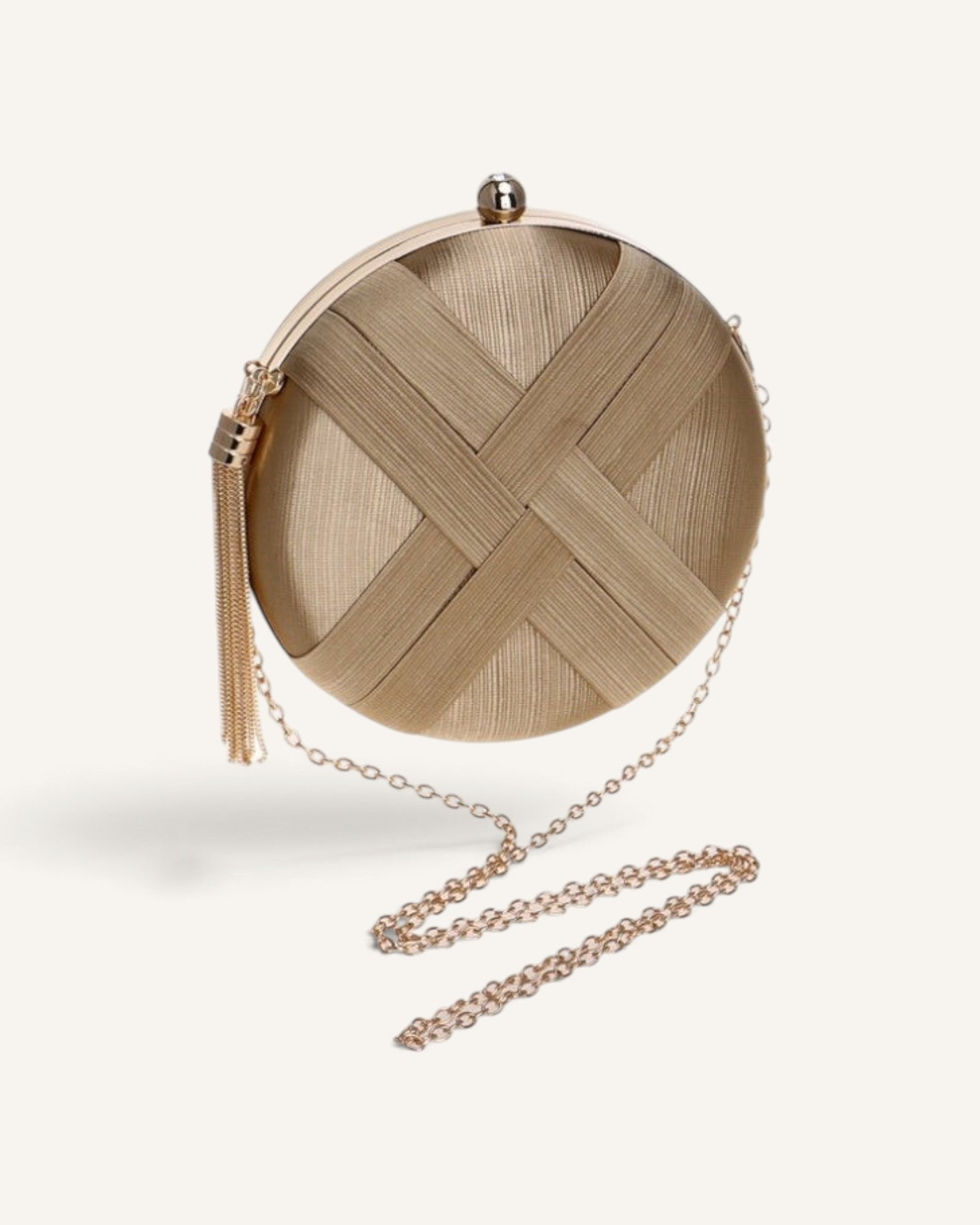 Lunéra de Paris circular evening clutch in metallic gold with a woven-effect finish, tassel detail, and chain strap.