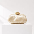 Lunéra de Paris oval acrylic clutch in a marbled champagne finish with a decorative gold-tone floral clasp