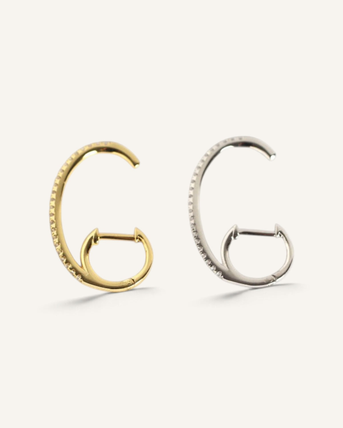 Lunéra de Paris gold and silver pavé curved open hoop earrings with hinge-post closure on a neutral background