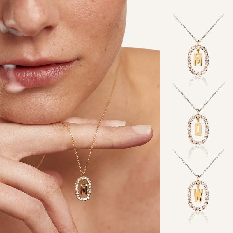 Lunéra de Paris gold pavé oval initial pendant necklace worn by a model, featuring a sparkling crystal-encrusted frame.