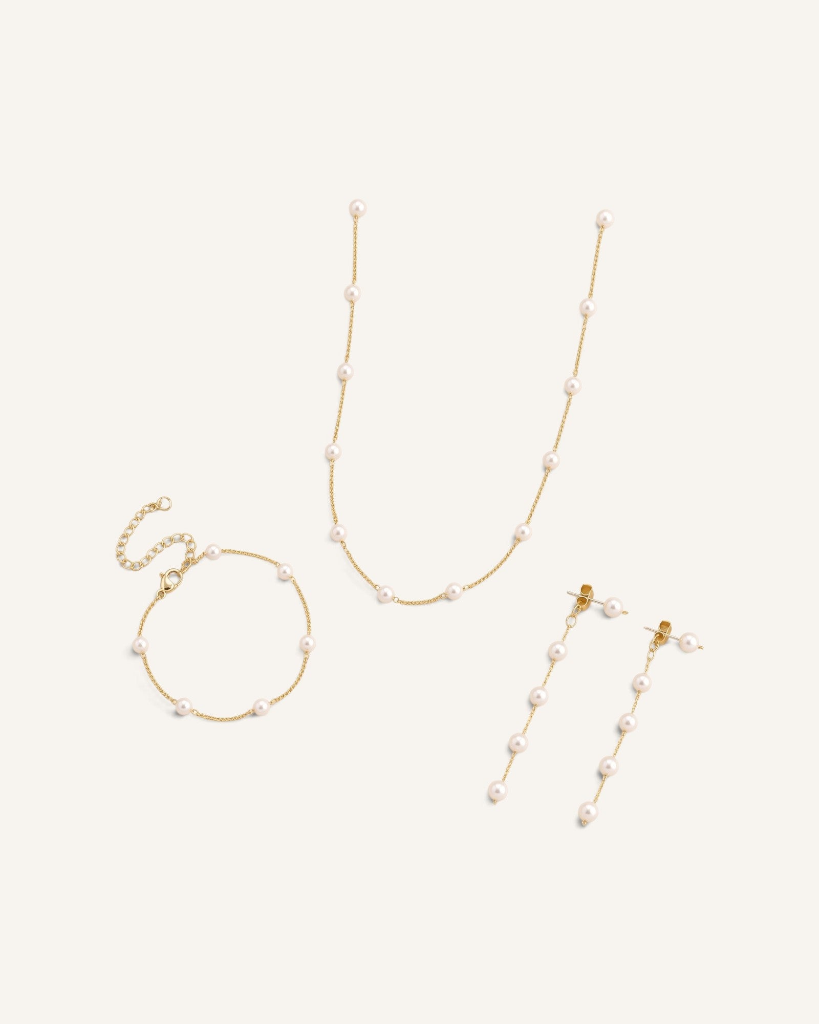 Lunéra de Paris three-piece jewelry set featuring gold-tone chains with delicate station-style white pearls