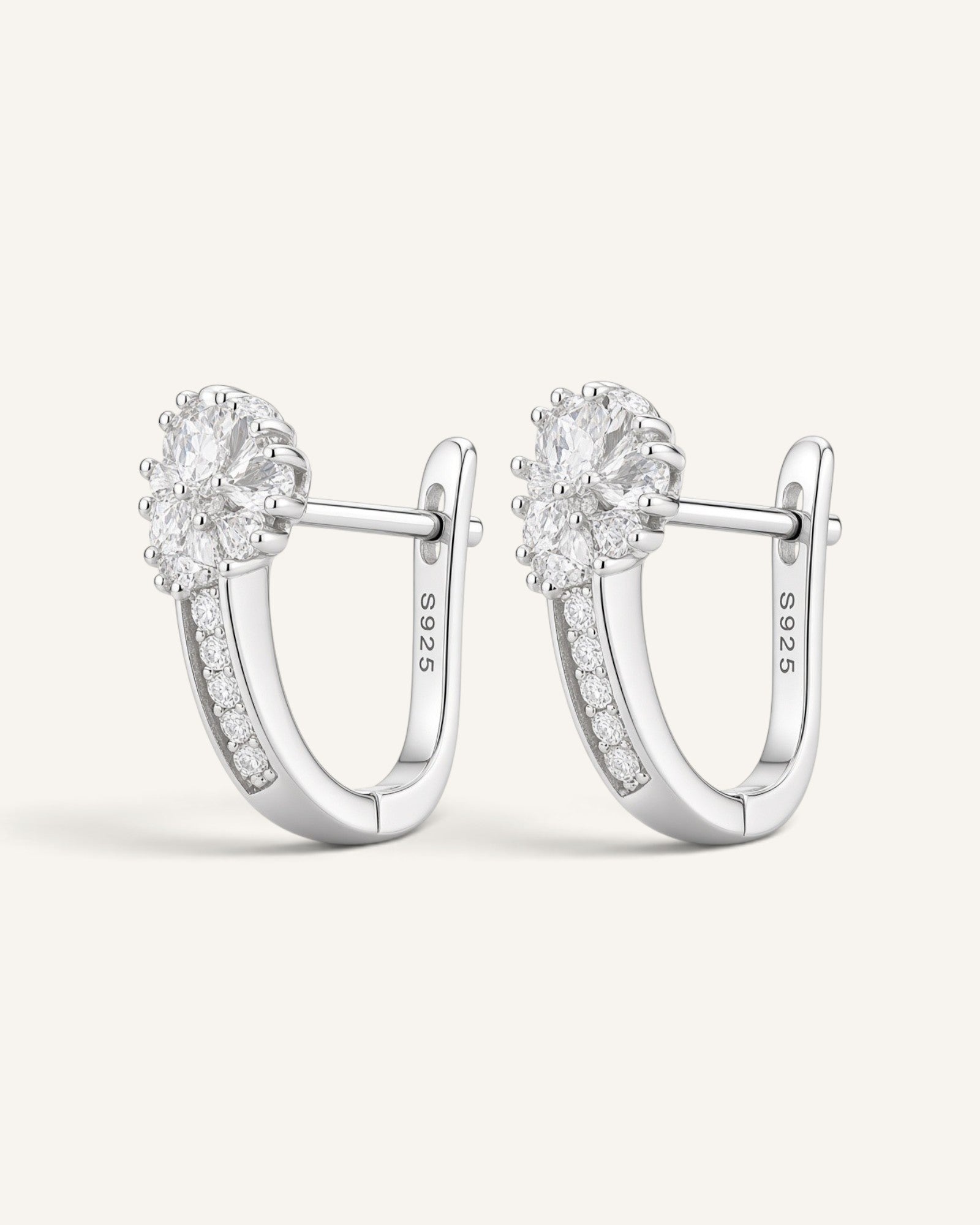 Lunéra de Paris silver-tone hoop earrings featuring a floral cluster of clear stones and a secure hinged closure.