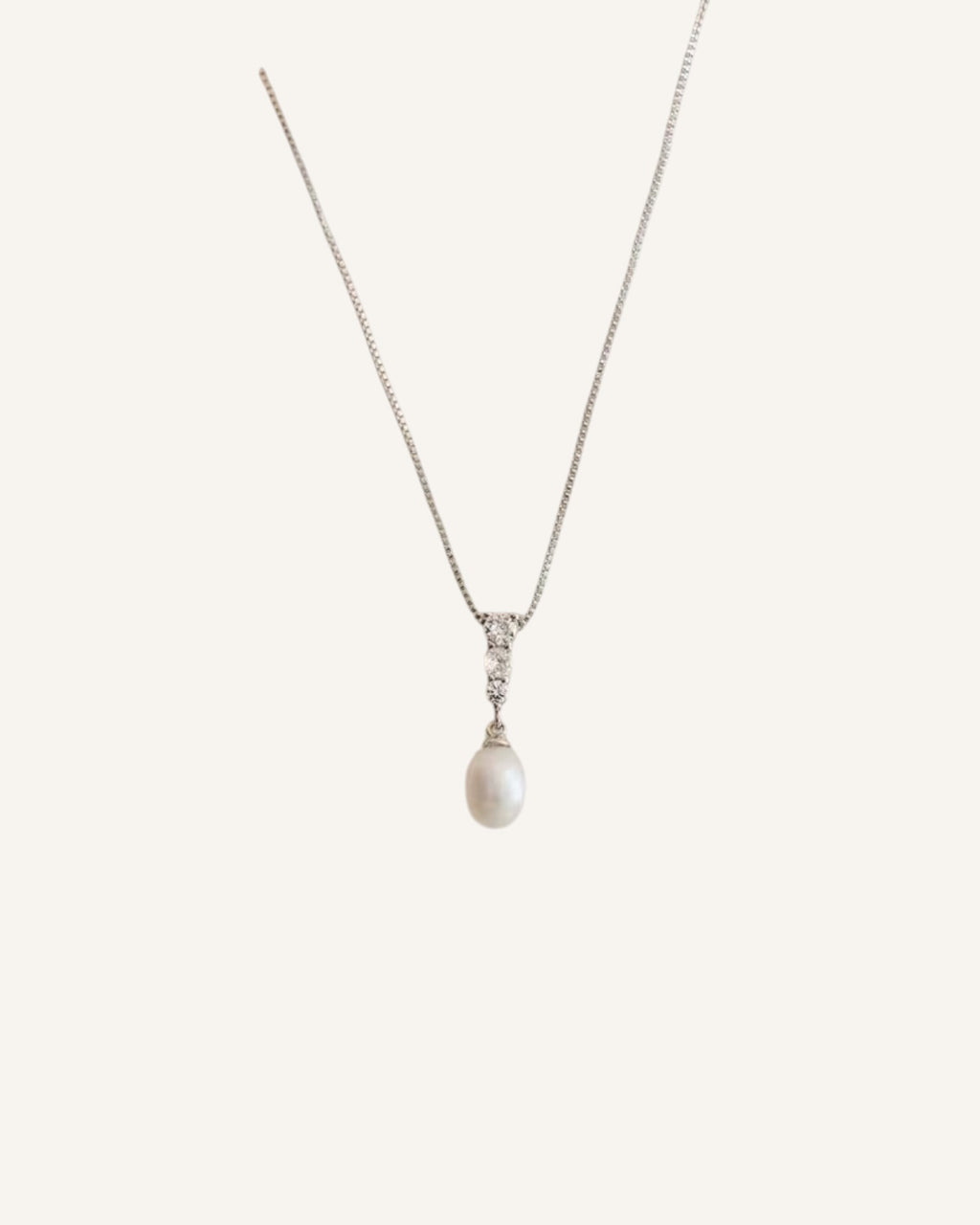 Lunéra de Paris silver-tone necklace featuring a teardrop pearl pendant with a trio of sparkling accents on a fine chain