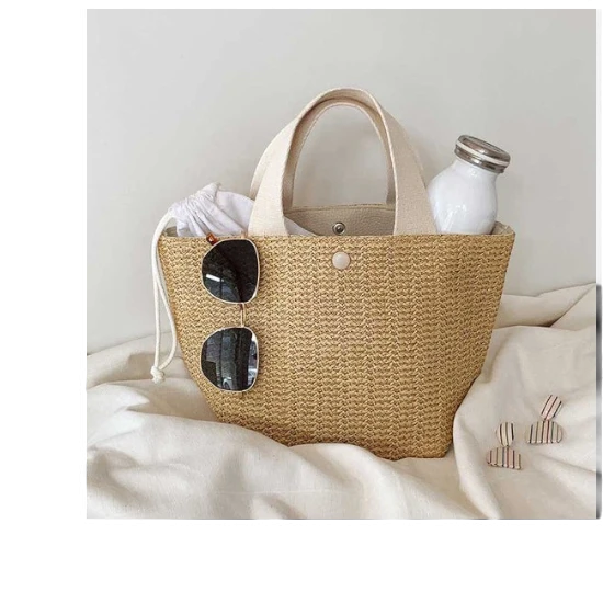 Lunéra de Paris Riviera woven beach bag with beige canvas handles and a structured bucket silhouette