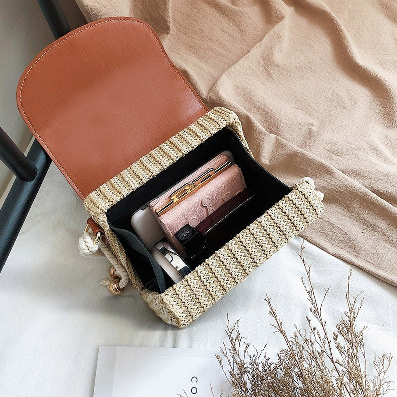 Lunéra de Paris woven crossbody bag in cognac with open interior showing wallet and essentials on a white surface