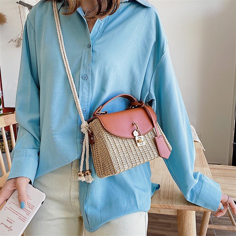 Lunéra de Paris woven crossbody bag in cognac with a top handle, rope strap, and floral charm on a turn-lock clasp.